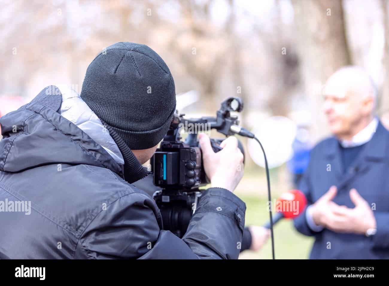 Un operatore di telecamere che riprende un'intervista mediatica Foto Stock