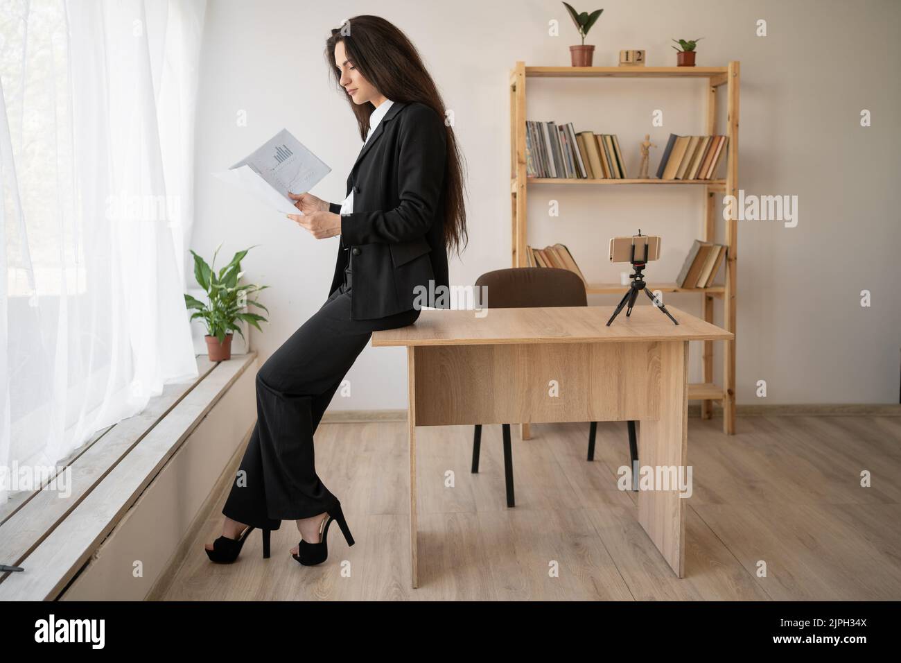 Elegante donna d'affari che legge i documenti o il rapporto fiscale in ufficio. Affari, finanza e persone Foto Stock