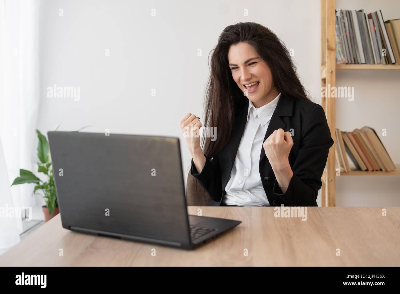 Felice entusiasta successo businesswoman trionfo in ufficio con le mani Foto Stock