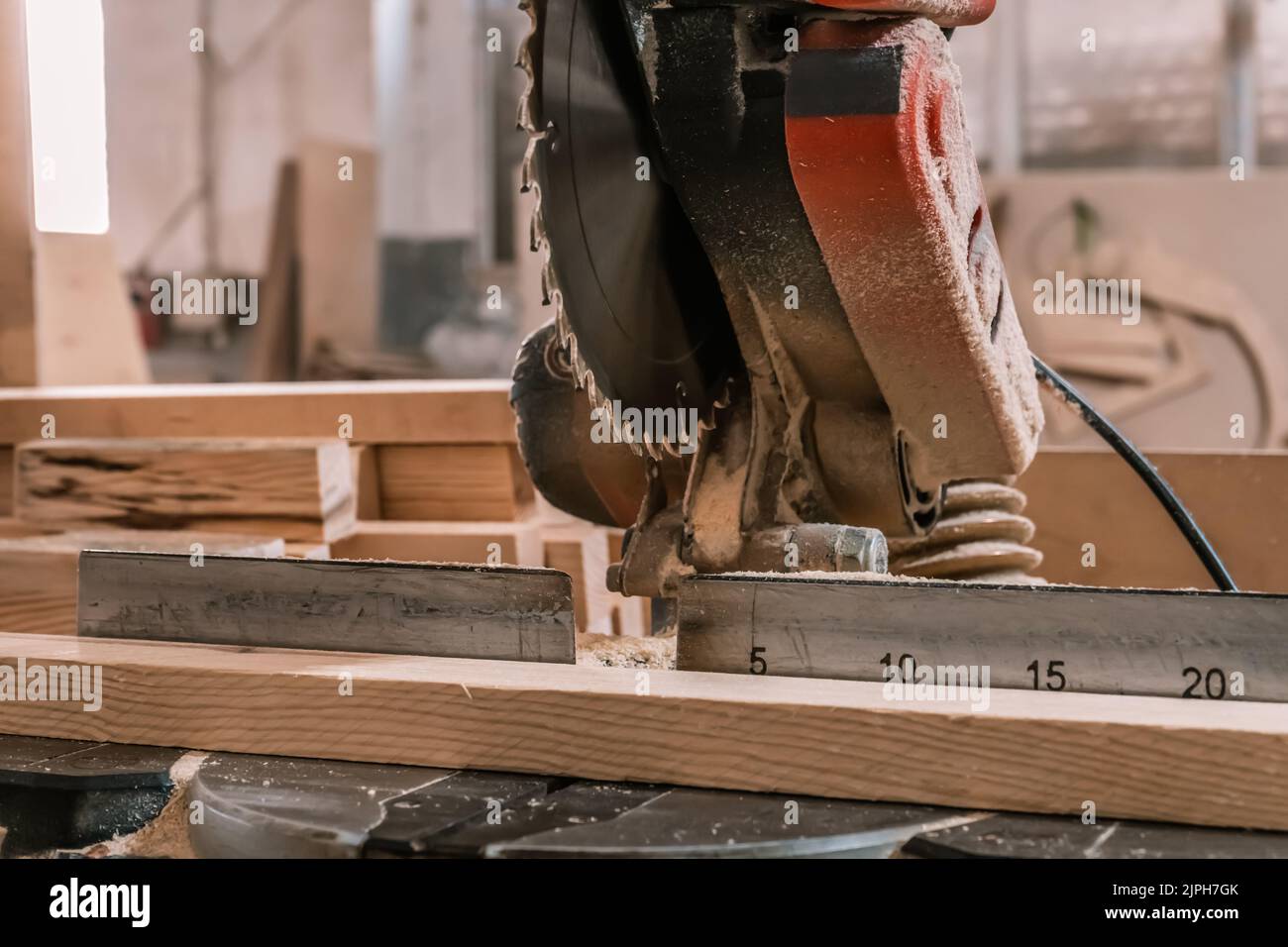 Segatrice per legno in officina per la produzione di mobili. Sega circolare per la lavorazione del legno e barra di legno per il taglio. Foto Stock