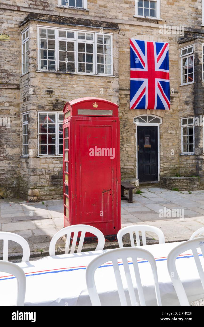 Casella telefonica rossa e bandiera Union Jack per le celebrazioni del Queens Platinum Jubilee a Swanage, Dorset UK, in una calda giornata di sole a giugno Foto Stock