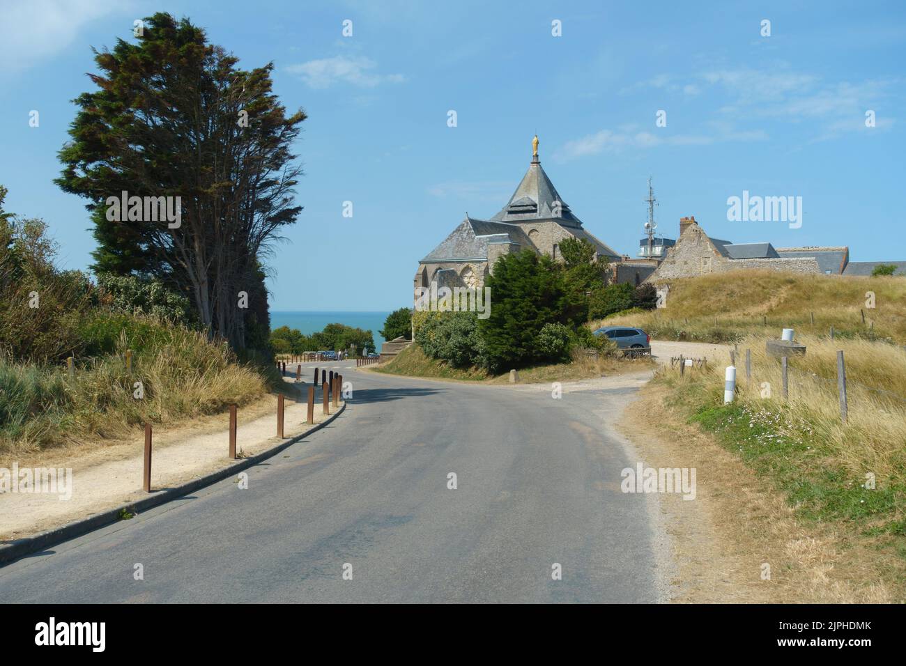 Una chiesa circondata da un paesaggio verde con una strada che vi conduce Foto Stock