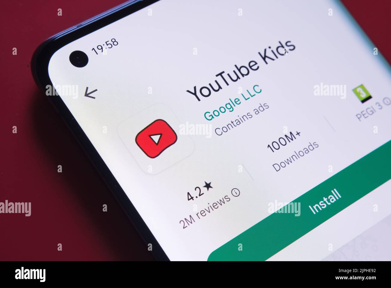 App YouTube Kids visualizzata in Google Play Store sullo schermo dello smartphone su sfondo rosso. Foto ravvicinata con messa a fuoco selettiva. Stafford, Ki Foto Stock