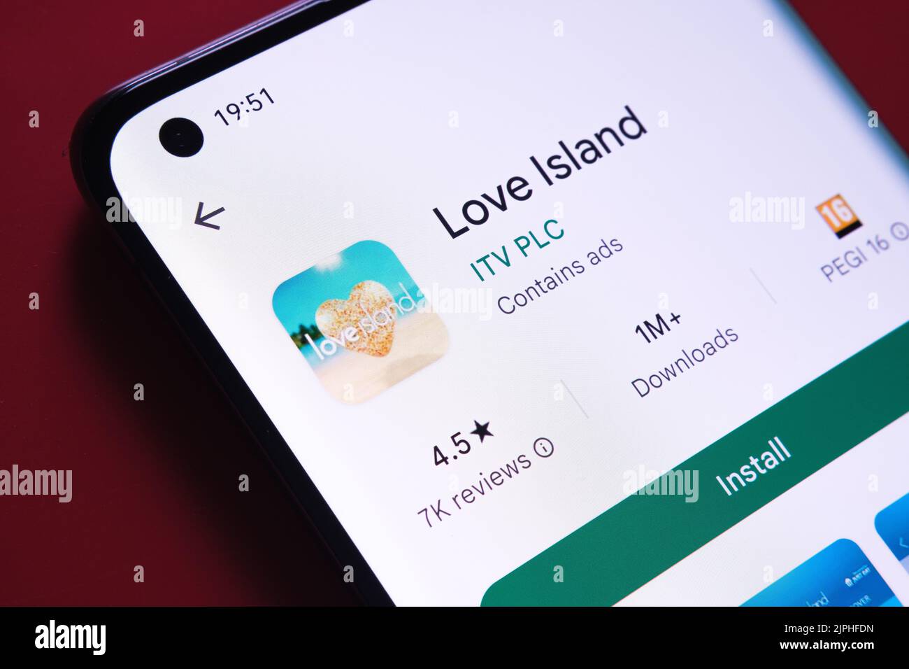 App Love Island visualizzata in Google Play Store sullo schermo dello smartphone su sfondo rosso. Foto ravvicinata con messa a fuoco selettiva. Stafford, Kin Foto Stock