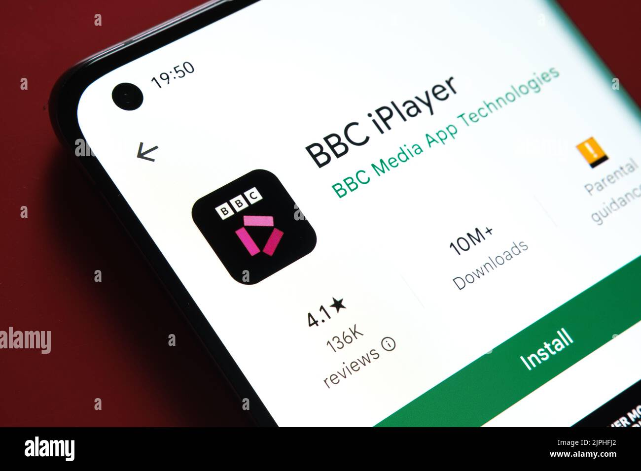 App BBC iPlayer visualizzata in Google Play Store sullo schermo dello smartphone su sfondo rosso. Foto ravvicinata con messa a fuoco selettiva. Stafford, Kin Foto Stock