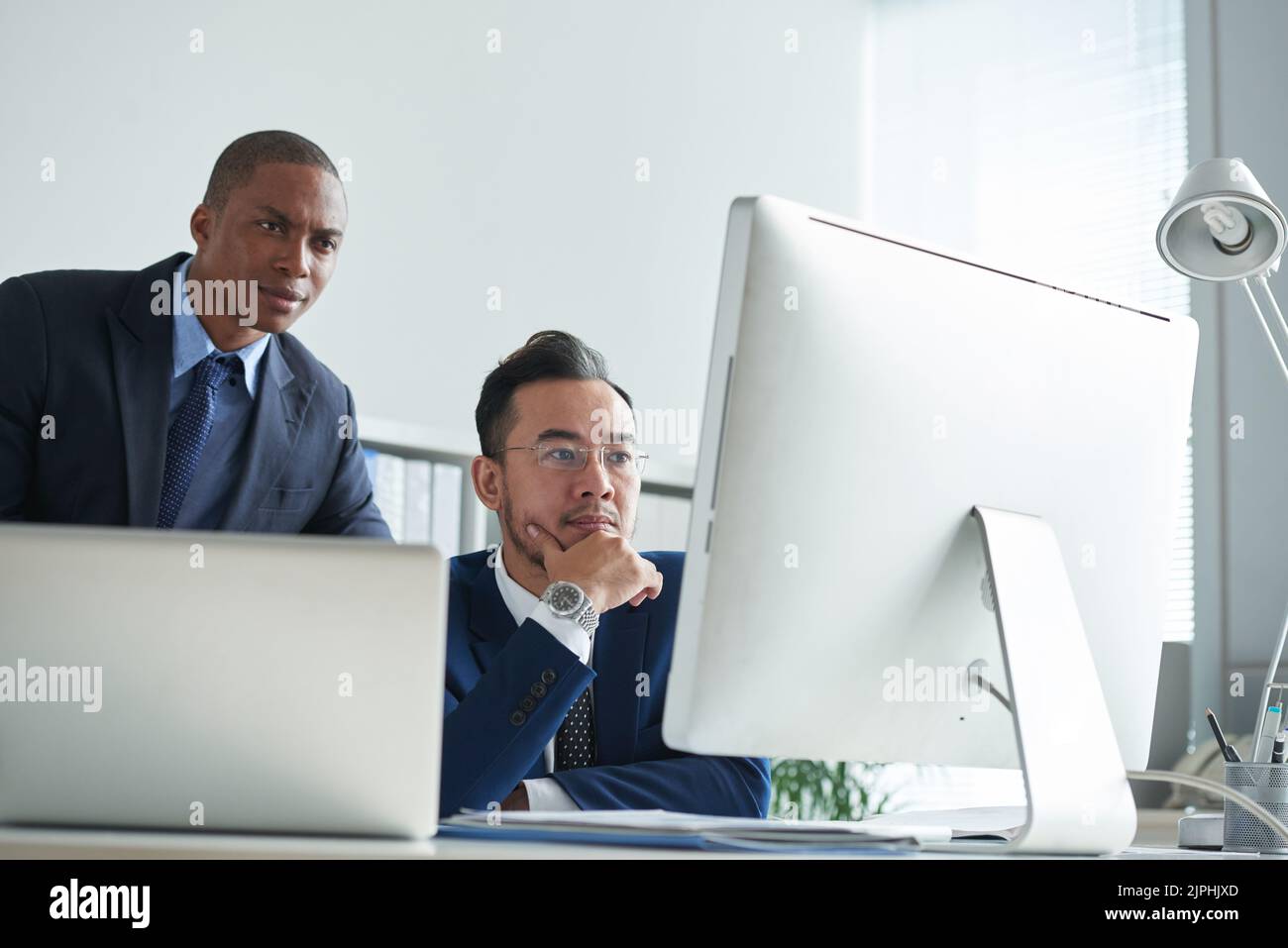 I gestori finanziari analizzano la situazione del mercato via computer Foto Stock