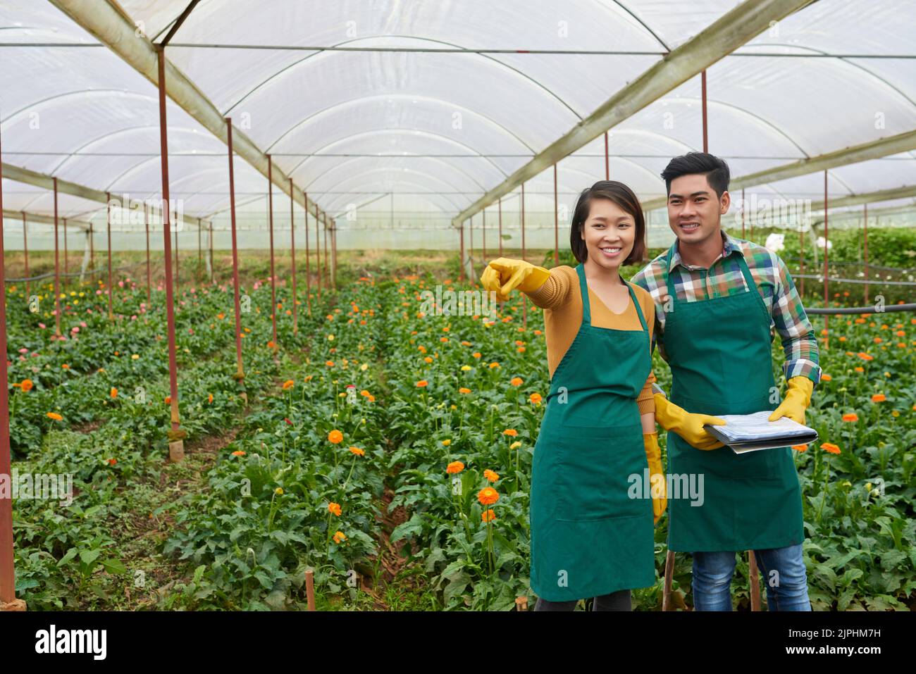 Giovane coppia vietnamita che lavora in serra di fiori Foto Stock