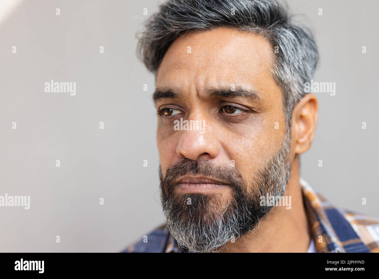 Uomo biraciale che indossa una camicia con maglietta bianca e pensiero Foto Stock