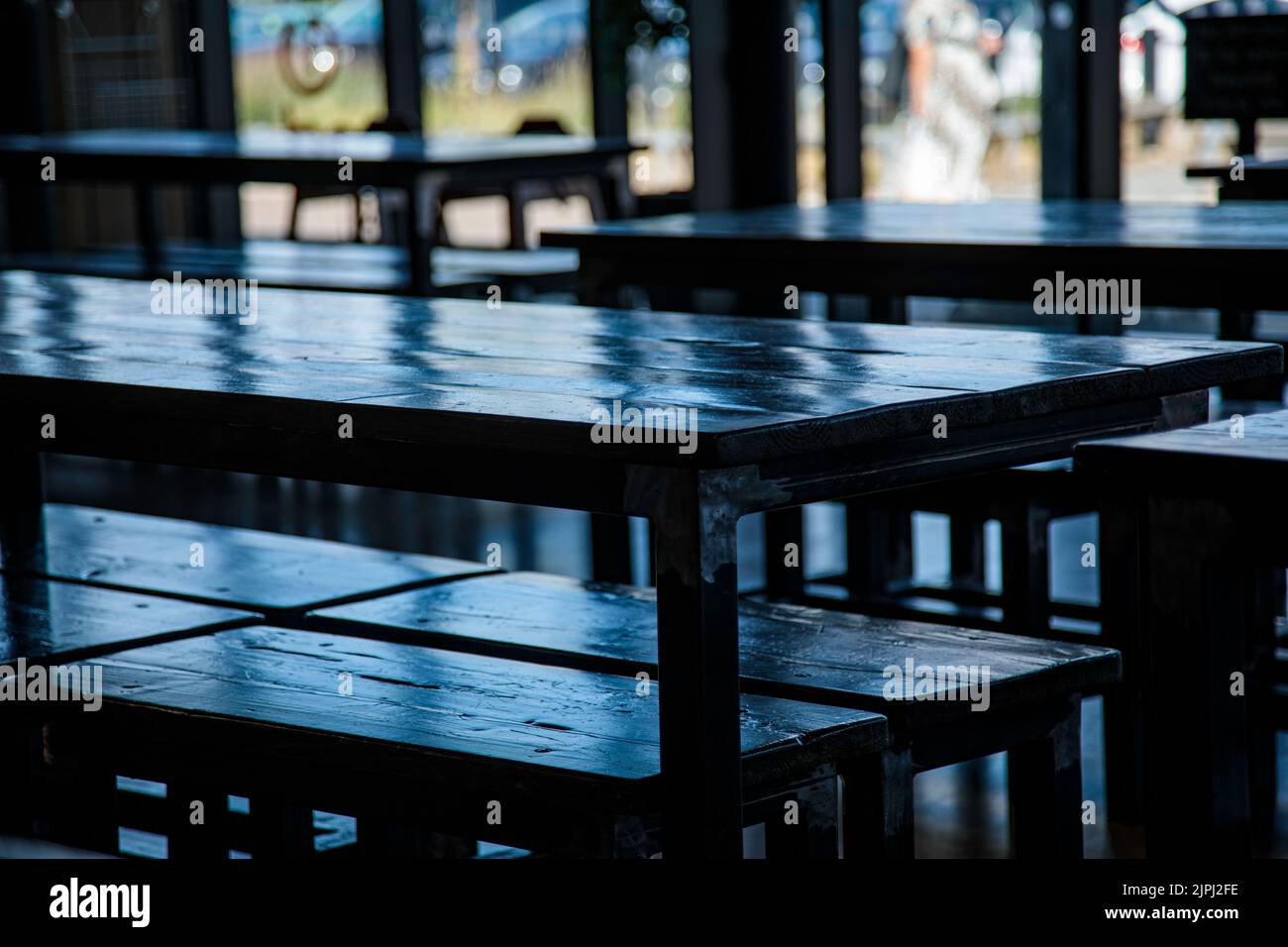 Grande tavolo in legno immerso nella luce della finestra Foto Stock