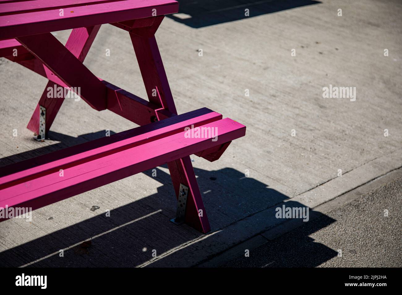 Colorate panchine da picnic in una piazza del mercato in una giornata di sole Foto Stock