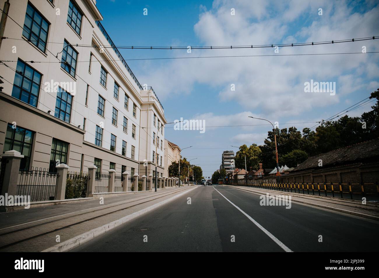 Una strada asfaltata nei pressi di edifici residenziali in una mattinata soleggiata Foto Stock