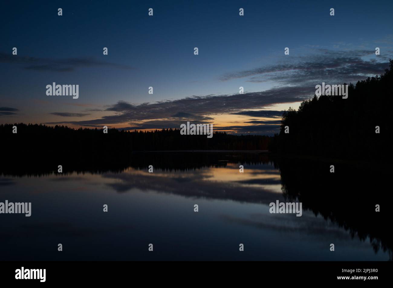 Notte d'estate sul fiume, cielo e nuvole che si riflettono sull'acqua. Foto Stock