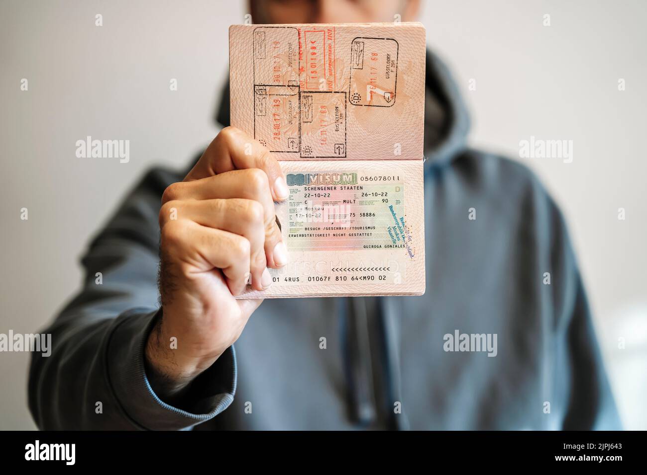 Passaporto straniero russo nelle mani di un uomo. Divieto di visto Schengen per i turisti russi di viaggiare verso l'Unione europea. Foto di alta qualità Foto Stock