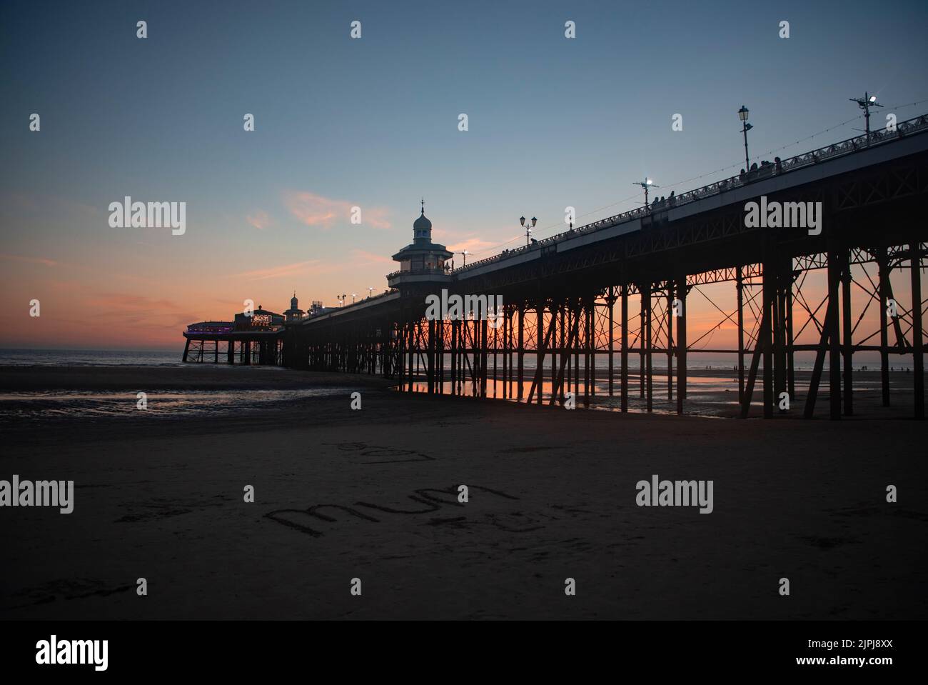 Blackpool - North Pier a Sunset e la parola 'MAMMA' scritta nella sabbia sulla spiaggia - Regno Unito Estate Vacanze Destinazioni, 2022 Foto Stock