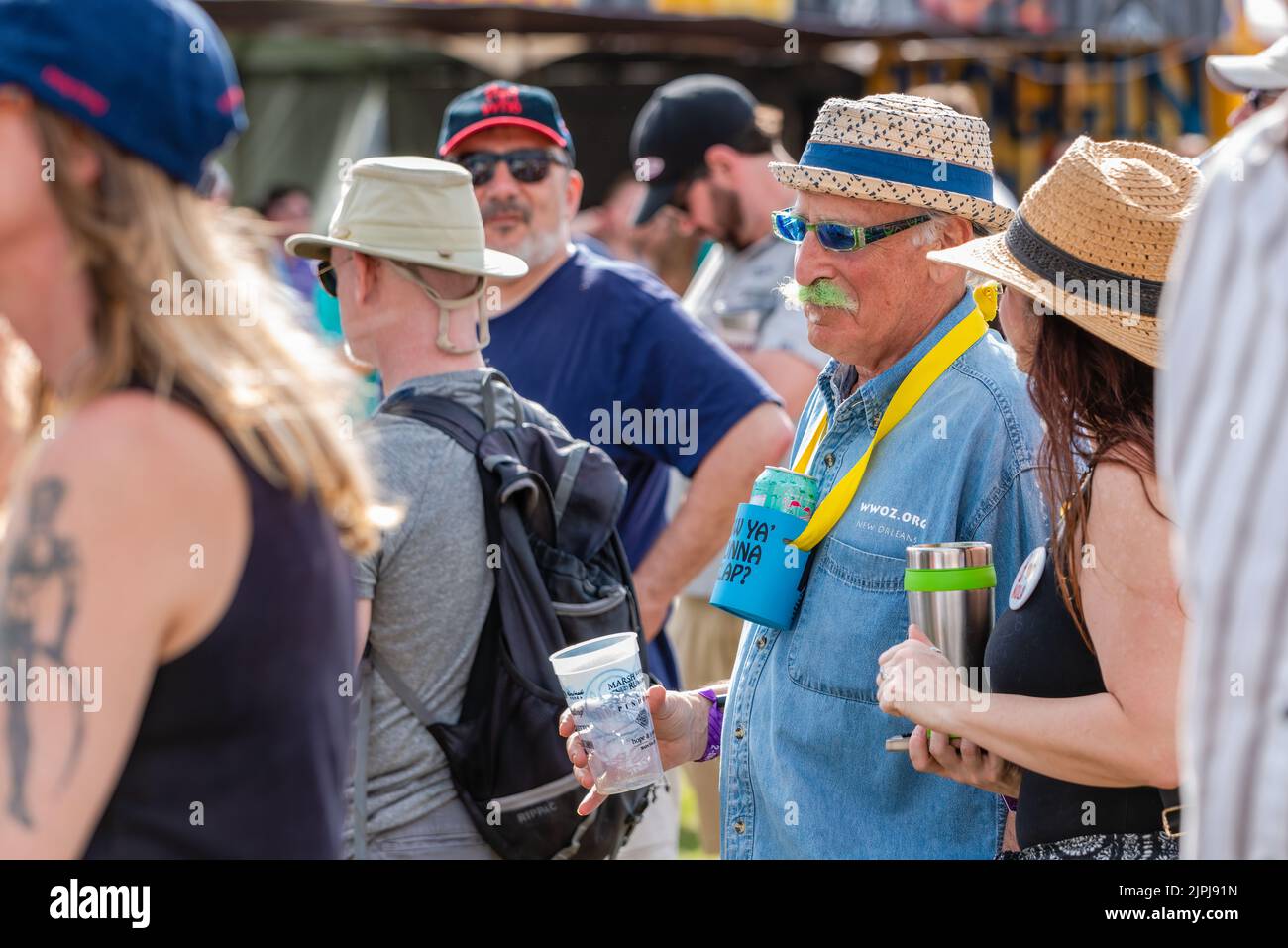 NEW ORLEANS, LA, USA - 30 MARZO 2019: Baby boomer con baffi verdi focalizzato selettivamente tra la folla in un festival all'aperto Foto Stock