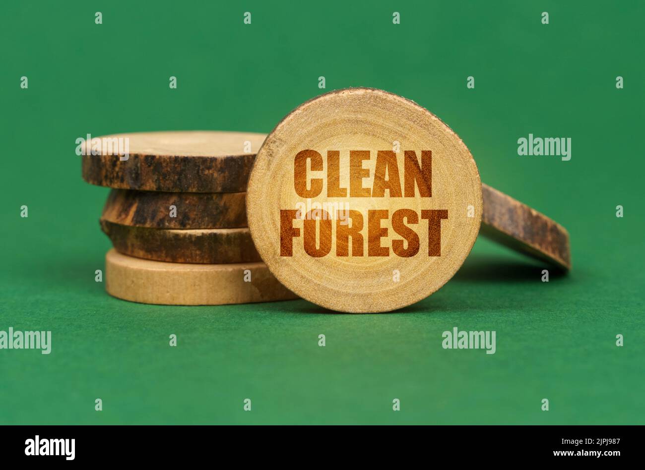 Concetto ecologico. Su una superficie verde, cerchi di legno su un'iscrizione - foresta pulita Foto Stock