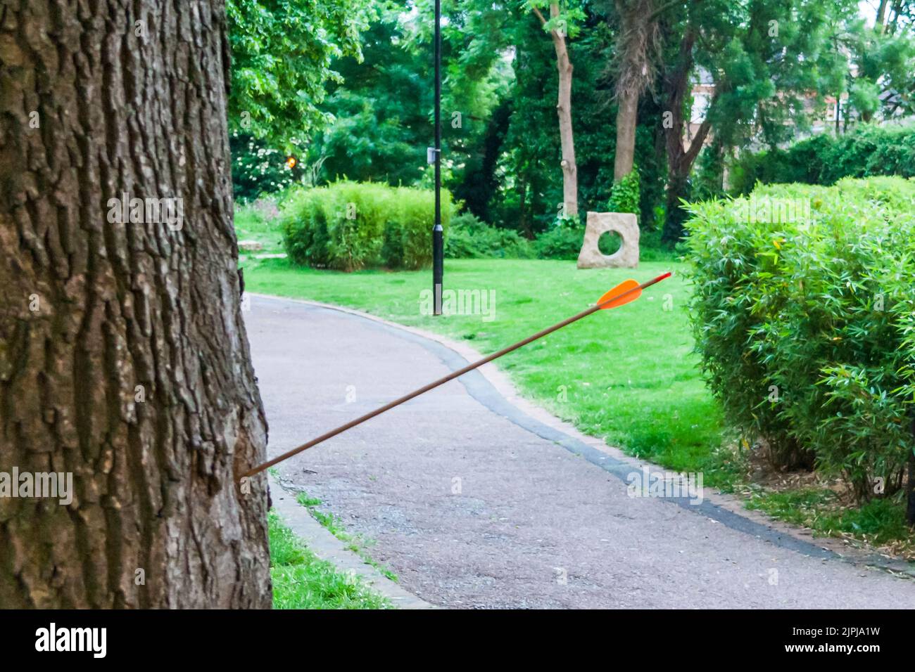 Una freccia incorporata nel tronco di un albero in un Hillside Park, uno spazio verde a Islington, Londra, Regno Unito Foto Stock