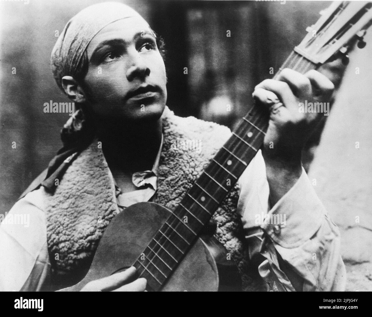 RUDOLPH VALENTINO è Juan Gallardo in SANGUE E SABBIA ( 1922 - SANGUE e ARENA ) di Fred Niblo , da Sangre y arena di Vincente Blasco Ibanez - publicity Still - RODOLFO VALENTINO - serenata - chitarra - chitarra - FILM MUTO - bandanna - bandana - foulard -- -- Archivio GBB Foto Stock