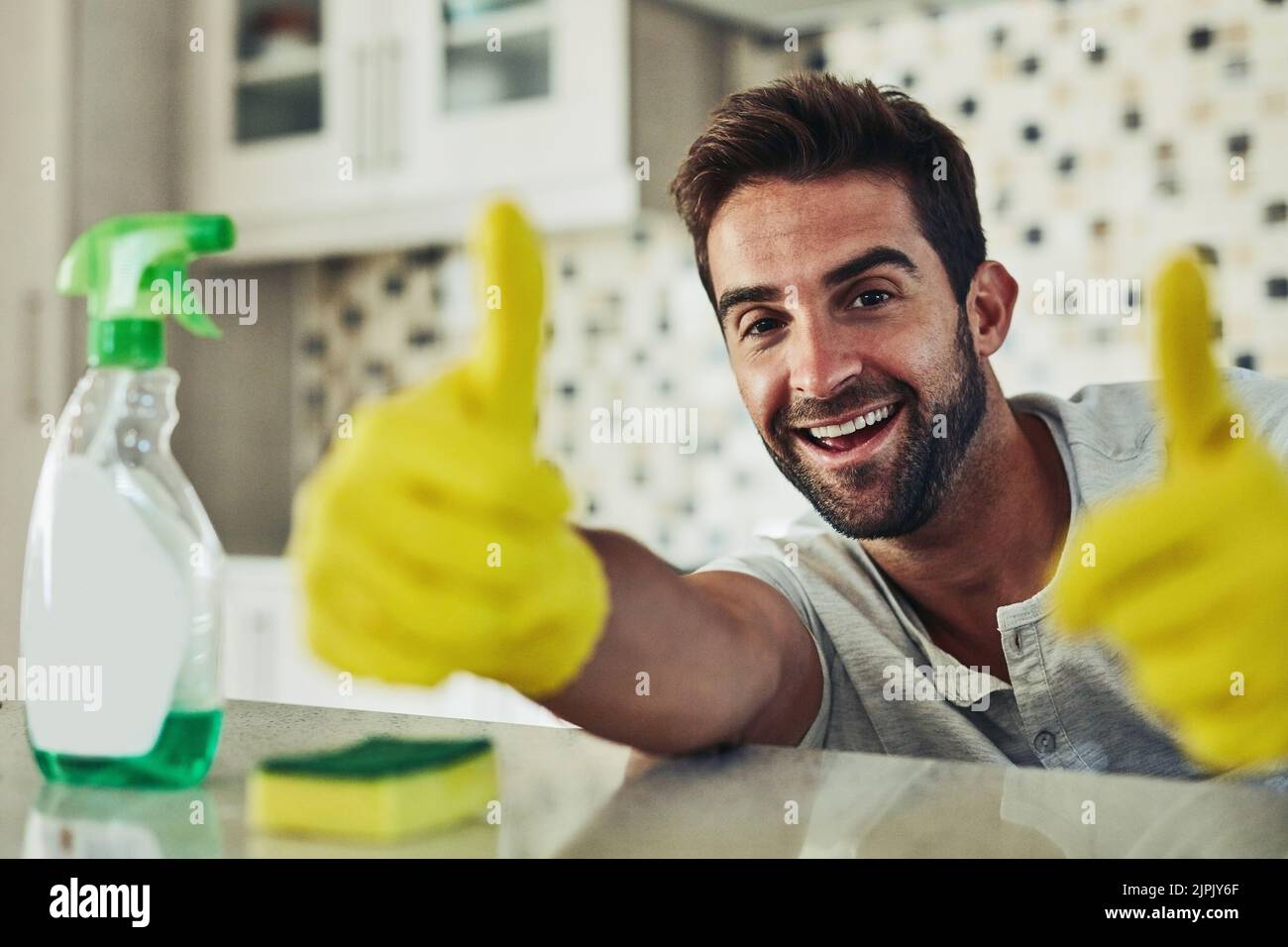 Il lavoro di casa non è solo per le donne, un bel giovane che pulisce la sua casa. Foto Stock