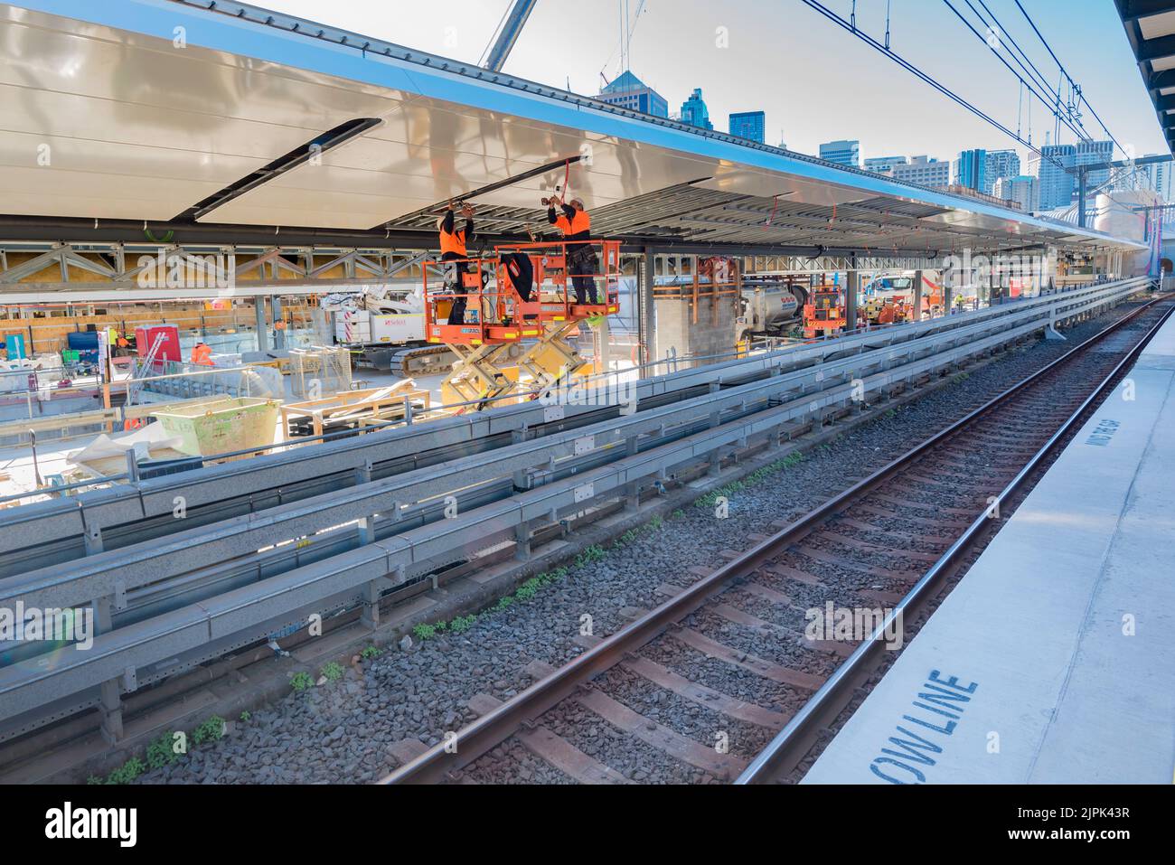 8 giugno 2022: Persone che lavorano sul tetto delle nuove piattaforme ferroviarie della metropolitana presso la stazione centrale di Sydney, Australia, in sicurezza ad alta visibilità PPE. Foto Stock