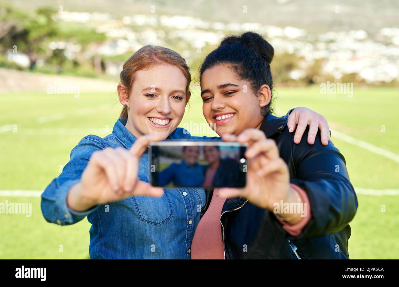 I migliori amici per sempre fotografano il giorno. Amici femminili scattano una foto insieme fuori. Foto Stock