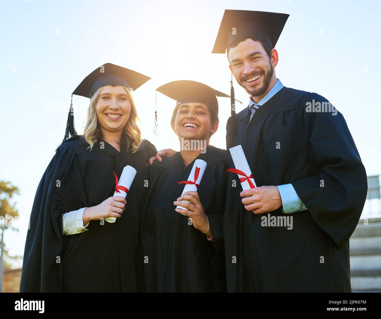 È la fine della nostra carriera accademica, ma non la nostra amicizia. Ritratto di un gruppo di studenti che hanno conseguito il diploma il giorno della laurea. Foto Stock