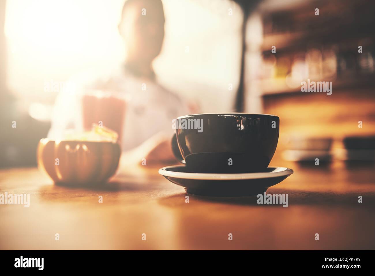Iniziate la giornata con una tazza di caffè perfetto, una tazza di caffè appena fatto su un tavolo di legno di un ristorante. Foto Stock
