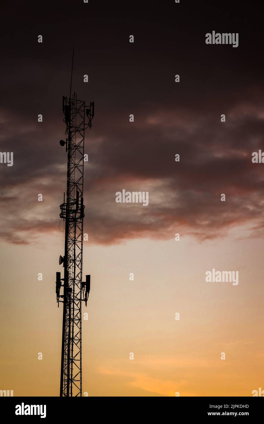 Antenna per telecomunicazioni durante il tramonto. Tecnologia cellulare. Spazio libero per scrivere. Foto Stock