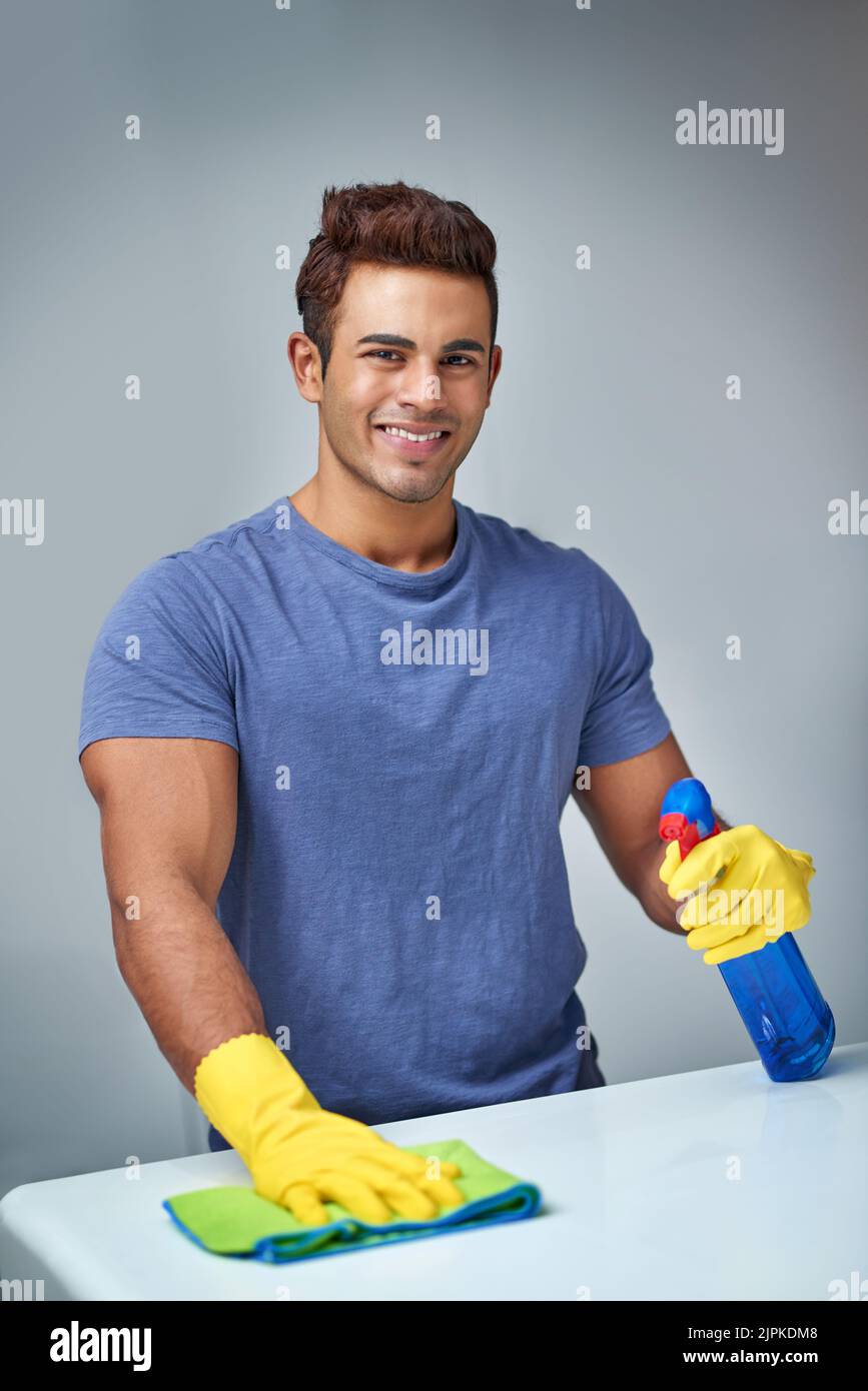 Sono pronto a pulire questo bancone, un giovane che fa le faccende domestiche. Foto Stock