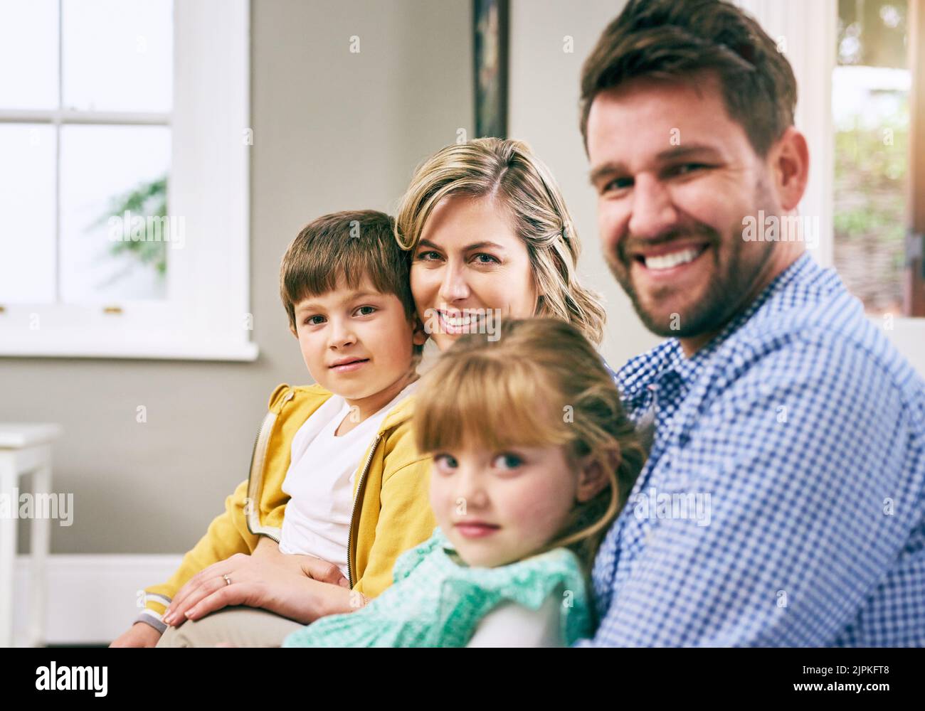 La famiglia significa passare del tempo insieme. Una famiglia seduta sul divano di casa. Foto Stock