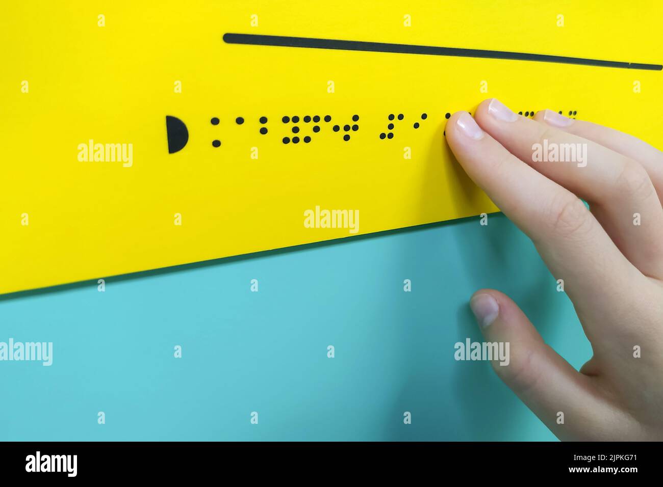 La mano del bambino sta leggendo il testo Braille Foto Stock
