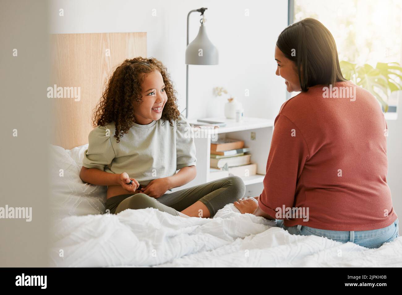 Madre premurosa che insegna al bambino a prendere l'iniezione di insulina da sola guardando felice, orgoglioso e coraggioso a casa. Bambina che si inietta con zucchero nel sangue Foto Stock