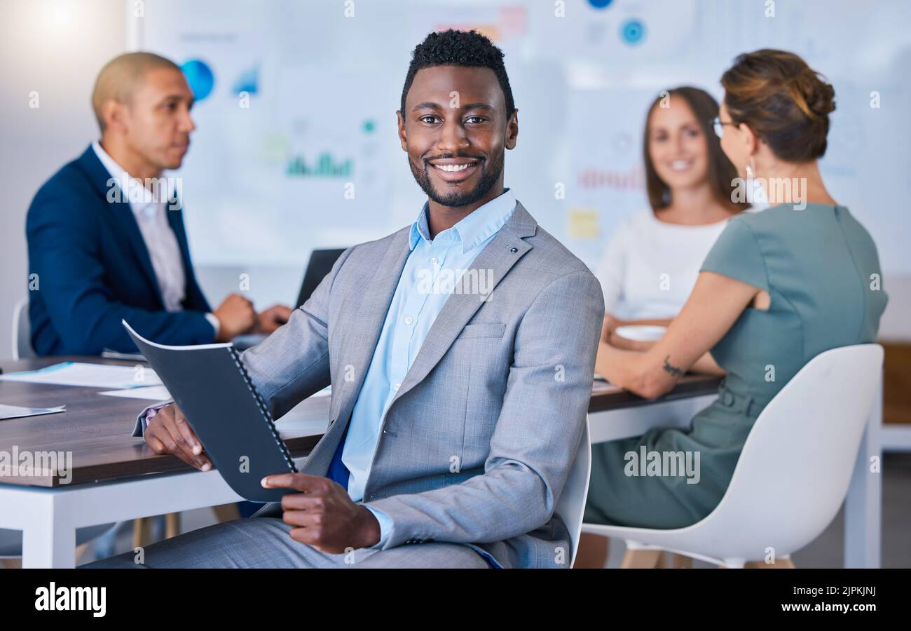 Ritratto di un uomo d'affari fiducioso che conduce una riunione in un ufficio moderno, sorridente e dotato. Buon maschio nero che discute le strategie innovative Foto Stock