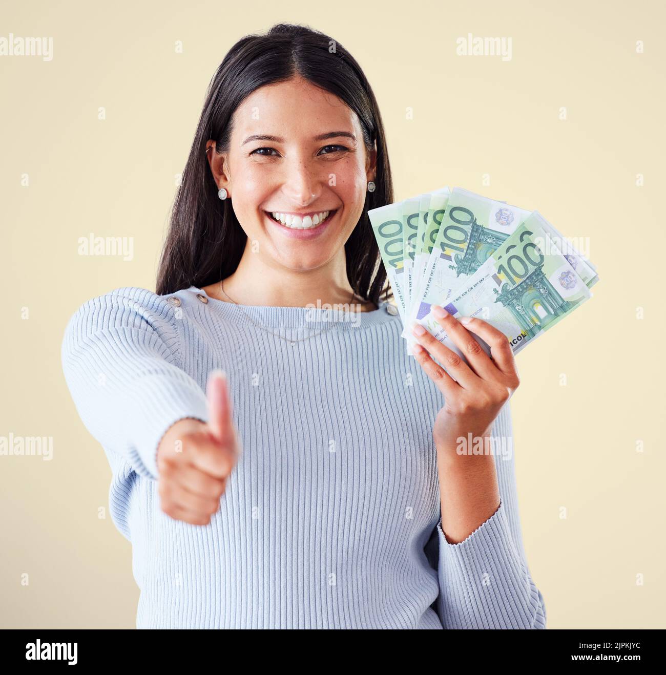 Thumbs in su, il denaro e la crescita finanziaria con contanti, banconote e valuta dopo gli investimenti, i risparmi e la lotteria vincere. Ritratto di eccitato, felice o. Foto Stock