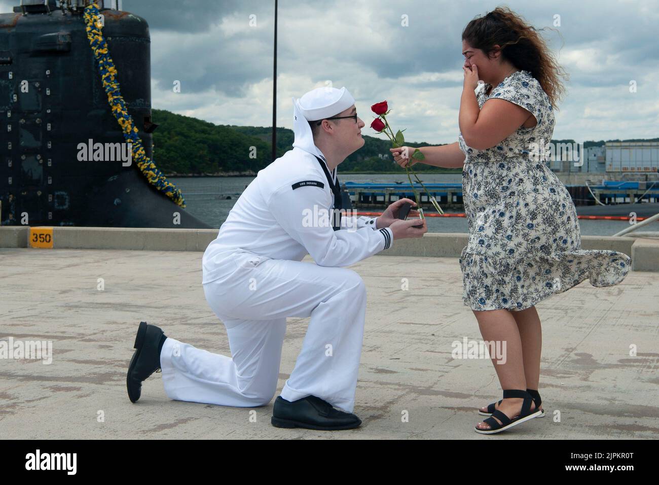 10 agosto 2022 - Submarine base New London, Connecticut, USA - Petty Officer 2nd Class Andrew Frable propone alla sua ragazza Nevada Currier durante un evento di ritorno per la USS Indiana (SSN 789) alla Naval Submarine base New London a Groton, Conn., Agosto. 10. L'Indiana è ritornata a homeport dal suo 2nd completo dispiegamento dal momento della messa in servizio a sostegno della strategia marittima della Marina - a sostegno degli interessi di sicurezza nazionale e delle operazioni di sicurezza marittima - nel 6th Fleet area delle operazioni. Il sottomarino ad attacco rapido di classe Virginia USS Indiana e l'equipaggio operano sotto il sottomarino Squadron (SUBRO Foto Stock