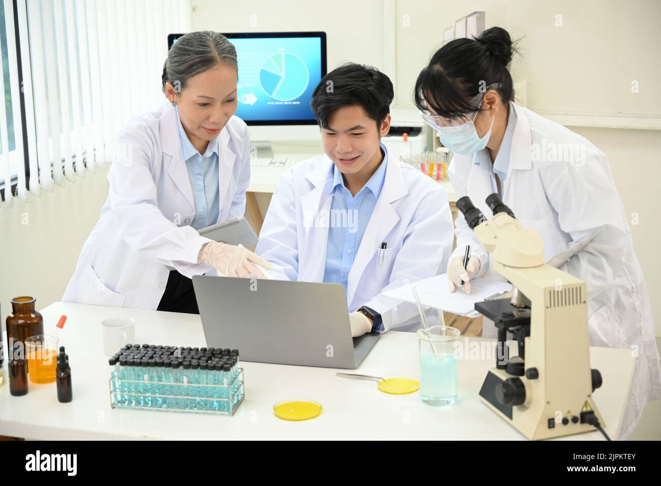 Un team di scienziati asiatici o chimici di talento e professionisti che lavorano insieme, con il brainstorming nel loro progetto nell'ufficio del laboratorio. Foto Stock