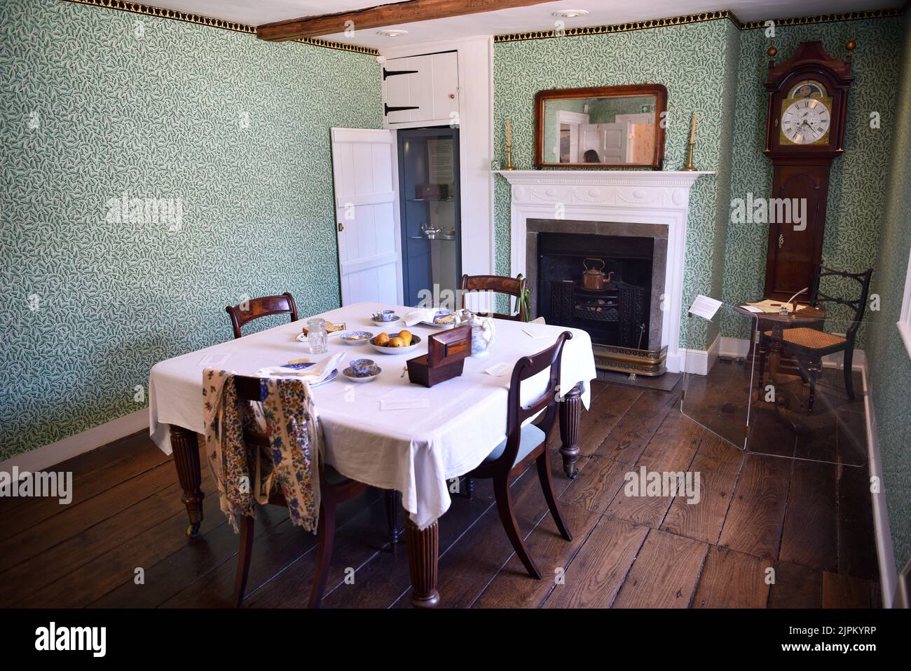 Sala da pranzo con la tavola di scrittura di Jane Austen sotto l'orologio, Jane Austen's House, Chawton, vicino ad Alton, Hampshire, REGNO UNITO. Foto Stock