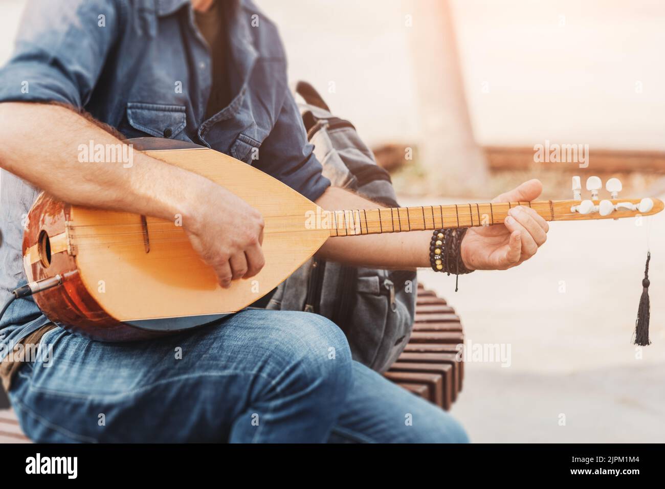 Musicista di strada che esegue canzoni popolari e suona su uno strumento tradizionale ottomano e turco baglama e saz ad archi Foto Stock