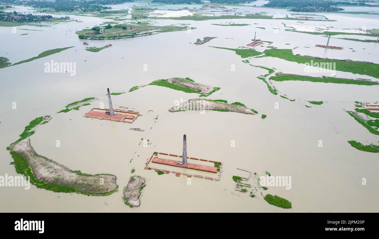 Dhaka, Dhaka, Bangladesh. 19th Set, 2022. Veduta aerea di un Chimney dalla fabbrica locale di mattoni allagata da piogge monsoniche vicino a Savar, Dhaka, Bangladesh. Centinaia di fabbriche di mattoni sembrano essere quasi scomparse sotto l'acqua a seguito di gravi inondazioni. Gli edifici sono stati coperti d'acqua durante l'intera stagione monsonica come forti precipitazioni dopo che un vicino fiume ha violato le sue banche.operai sono stati in grado di salvare migliaia di mattoni - ma molti sono stati persi al 20 piedi di acqua profonda. L'ultima agenda delle Nazioni Unite per l'incontro generale riguarda ''cambiamenti climatici''. Ora, è tempo, guardiamo forwa Foto Stock