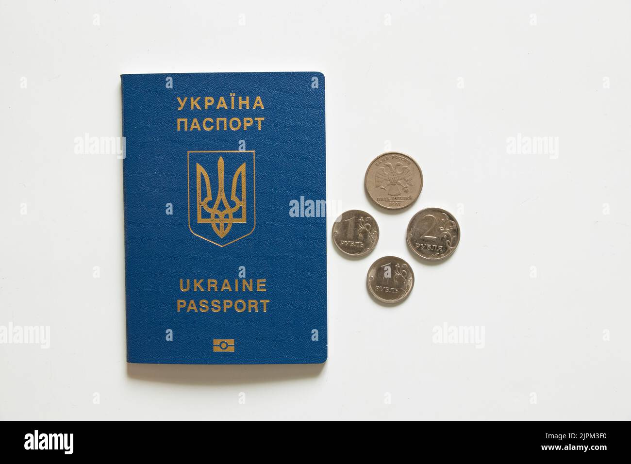 Passaporto ucraino straniero e rubli russi si trovano nelle vicinanze su uno sfondo bianco, economia e turismo, sanzioni in Russia 2022 Foto Stock