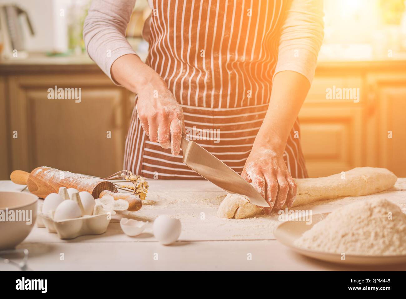 Vista ravvicinata di due donna di mani tagliate la pasta a coltello Foto Stock
