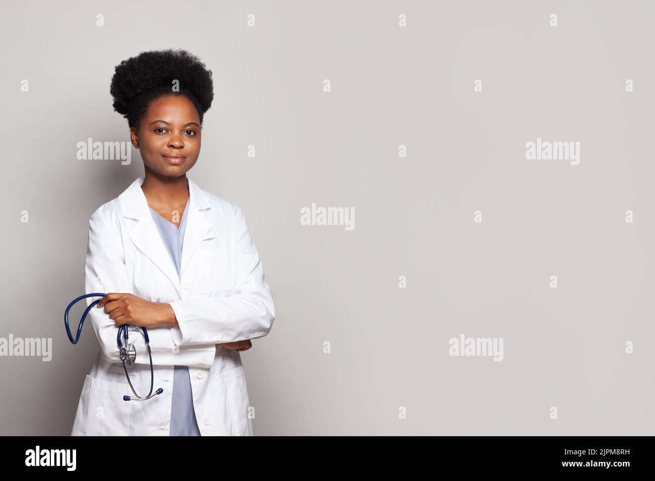 Donna medico gentile fiduciosa con stetoscopio su sfondo bianco Foto Stock