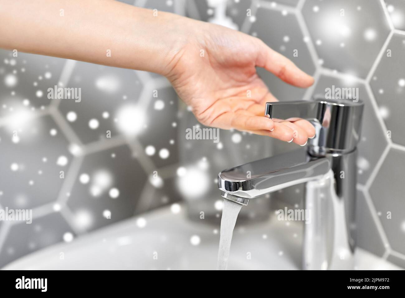 primo piano del rubinetto d'acqua con apertura a mano della donna Foto Stock