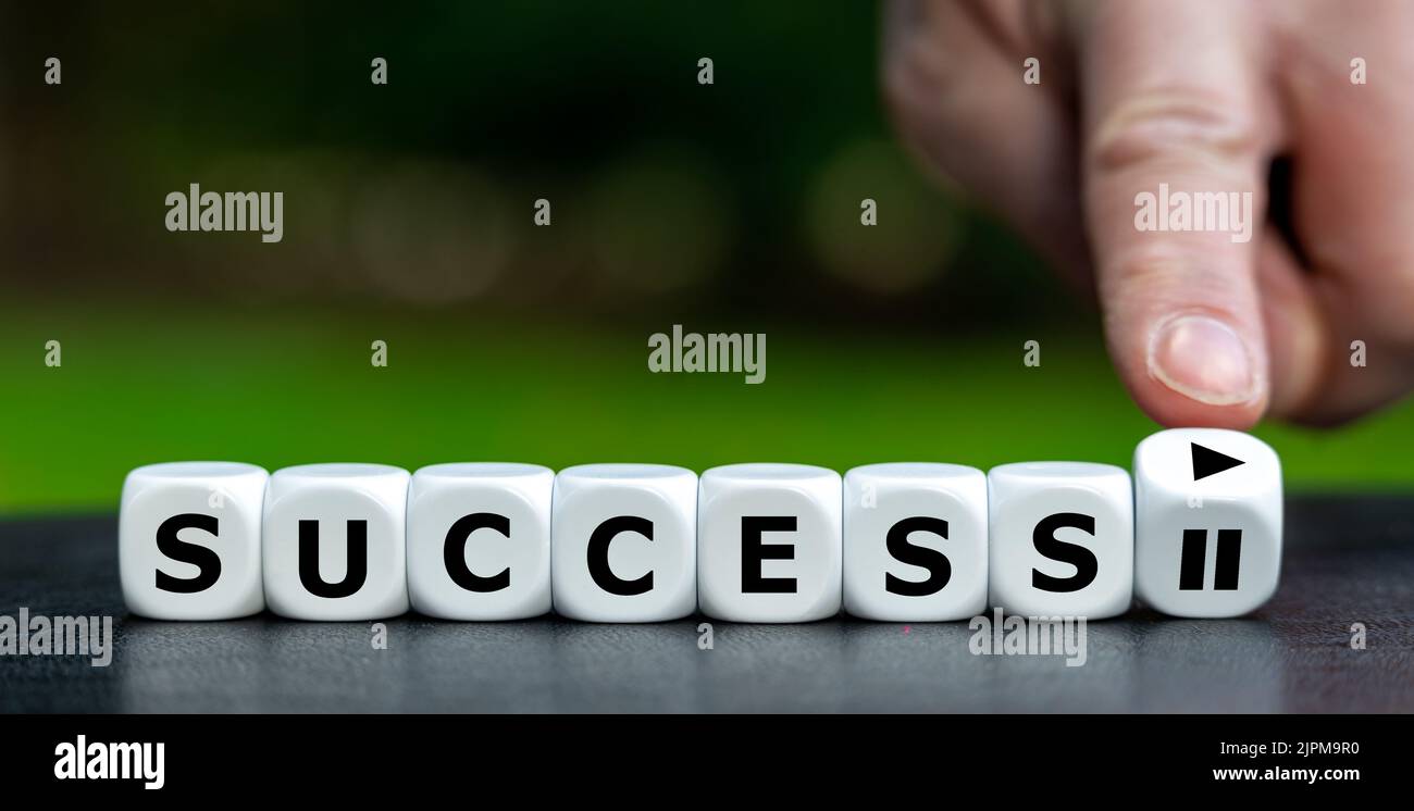 Simbolo per iniziare la vostra carriera. La mano gira i dadi e cambia il simbolo di pausa in un simbolo di gioco. Foto Stock