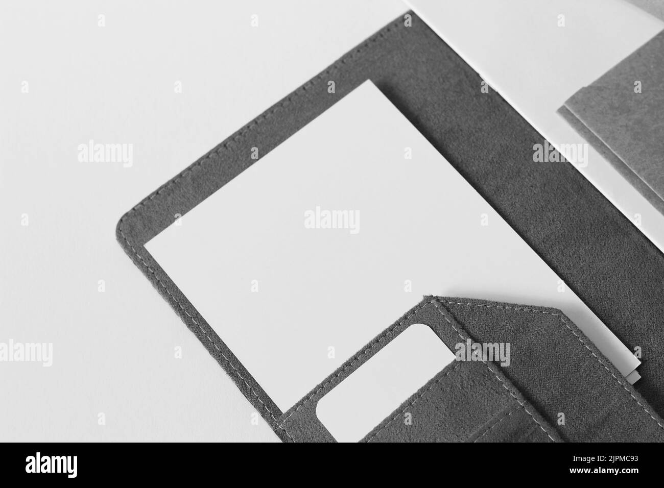 Minimo piano di scrivania. Cartella Office con fogli bianchi e schede bianche su sfondo bianco. Foto Stock