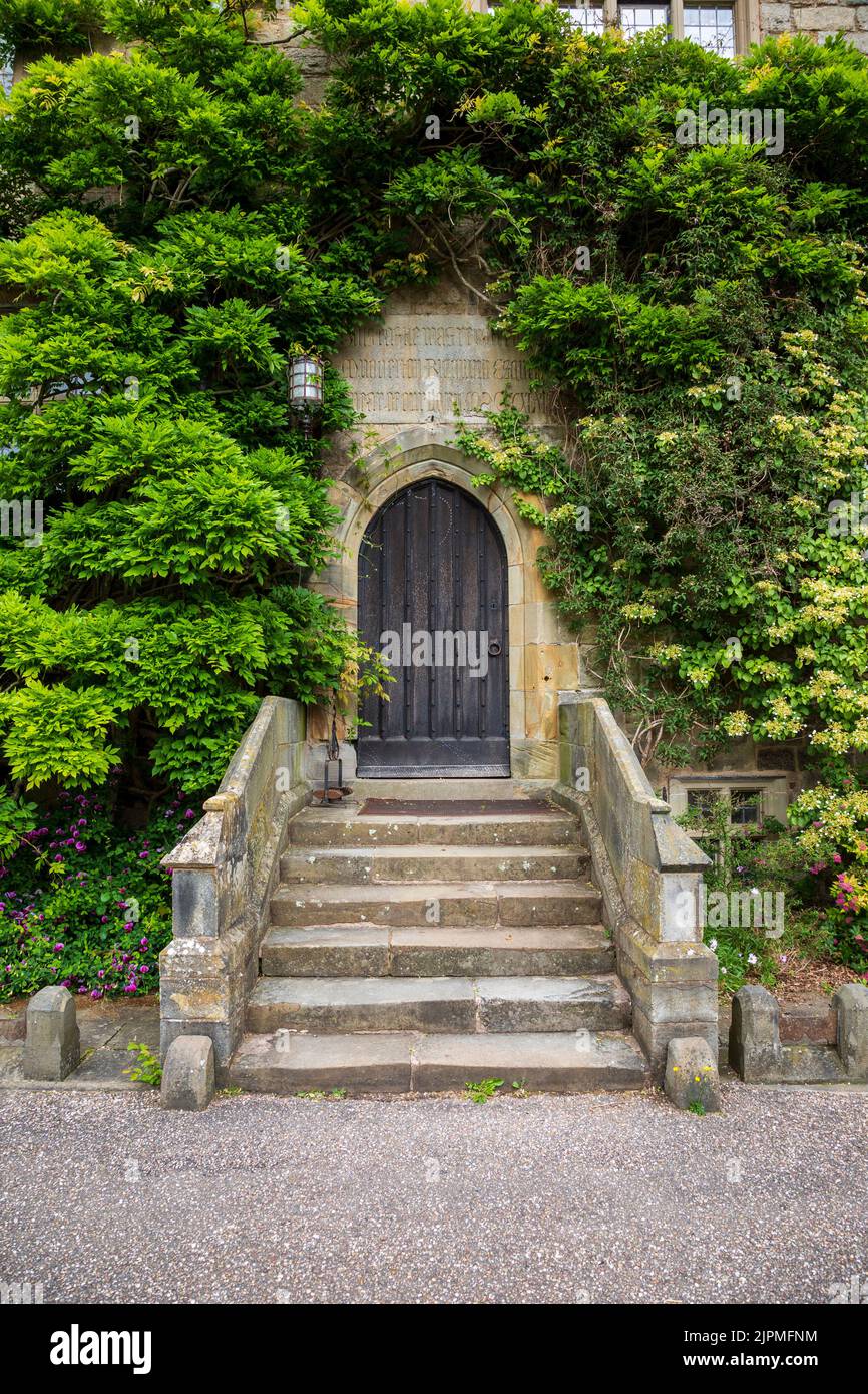Una porta d'ingresso avvolta in piante da arrampicata al castello di Chirk, Wrexham, Galles del Nord Foto Stock
