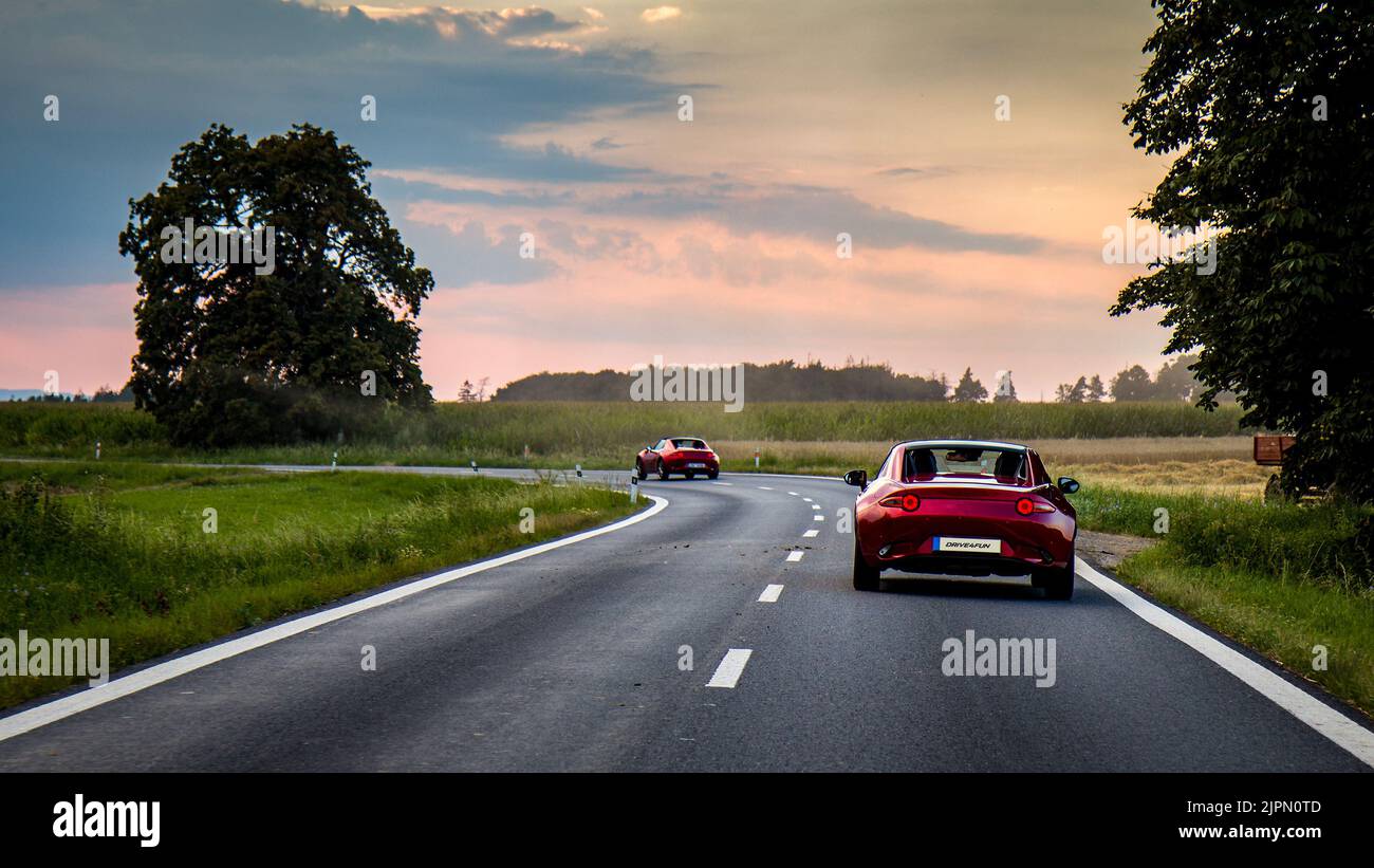 2 vetture sportive su una strada tortuosa incredibile quartiere - guidare per divertimento. MAZDA MX-5 ND RF. Miata. Incredibile strada tortuosa. Sfondo verde HD. Sfondo 4K. Foto Stock