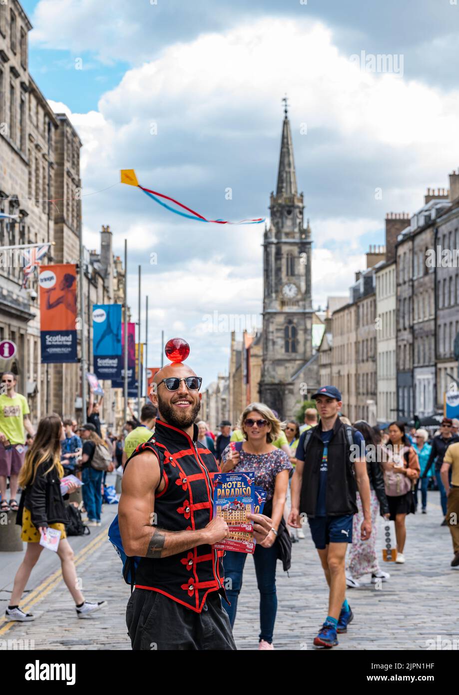 Edimburgo, Scozia, Regno Unito, 19th agosto 2022. Artisti fringe sul Royal Mile: La strada è piena di fringe-goers, artisti di strada e cast di spettacoli che distribuiscono volantini in una giornata di sole. Nella foto: Un circo performer da Lost in Translation Hotel Paradiso spettacolo circo. Credit: Sally Anderson/Alamy Live News Foto Stock