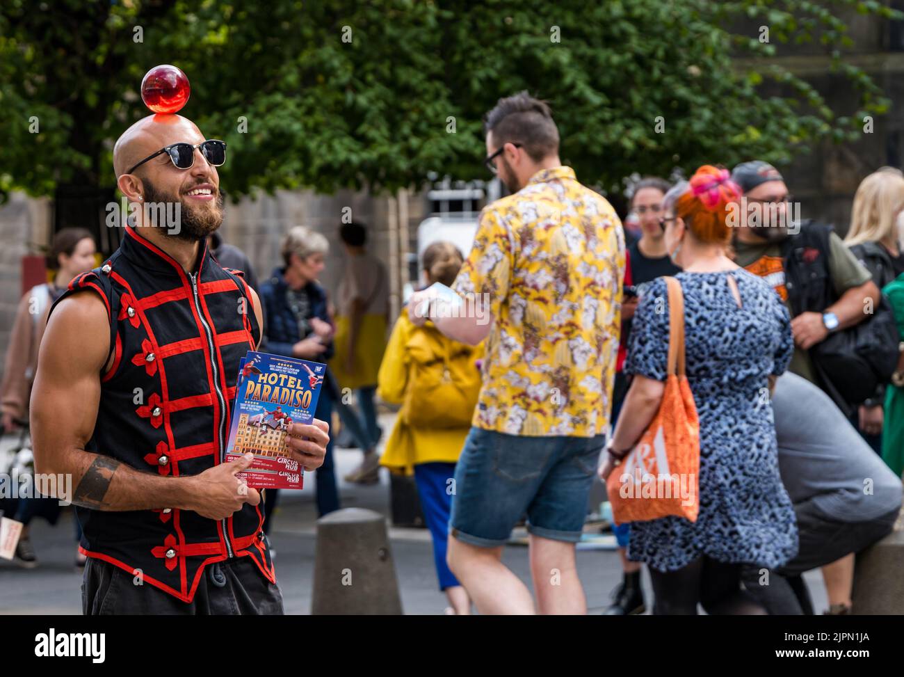 Edimburgo, Scozia, Regno Unito, 19th agosto 2022. Artisti fringe sul Royal Mile: La strada è piena di fringe-goers, artisti di strada e cast di spettacoli che distribuiscono volantini in una giornata di sole. Nella foto: Un circo performer da Lost in Translation Hotel Paradiso spettacolo circo. Credit: Sally Anderson/Alamy Live News Foto Stock