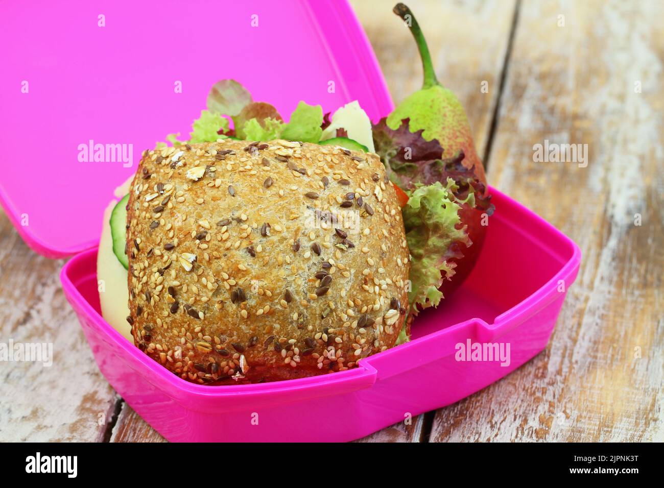 Lunchbox contenente panino intero con formaggio svizzero, lattuga, cetriolo e pera Foto Stock
